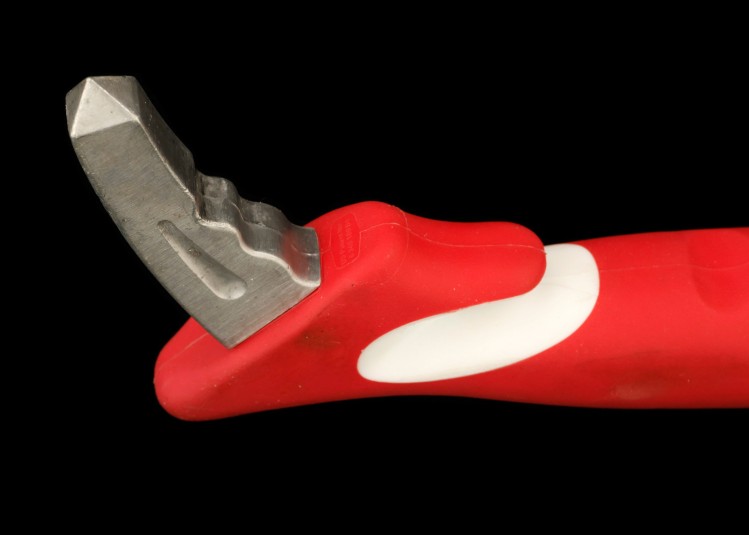 Close-up of the metal end of the tool, with the white slicing mechanism also visible, as well as a portion of the red handle.