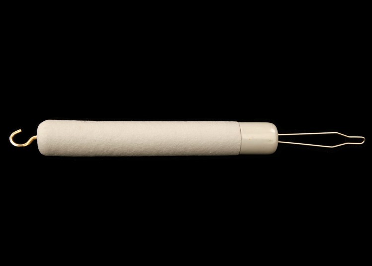 A cylindrical tool with a wire hook on one end (for grabbing zipper pulls) and a  wire loop on the other end (for grabbing buttons).
